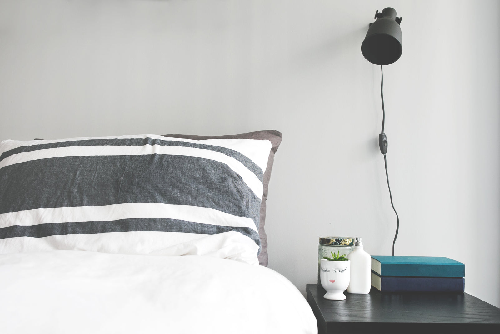 Schlafzimmer mit Leinen-Bettwäsche und Nachttisch